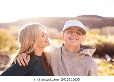 Mother playing with her cute teenage son. Having a happy moment together. Concept photo about parenting tough teenage children. Candid photo