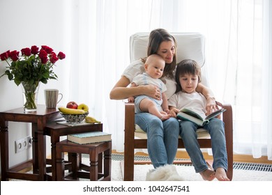 Mother, Playing With Her Toddler Boy And His Older Brother, Reading Book, Smiling, Breastfeeding