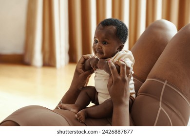 Mother playing with newborn baby after working out at home - Powered by Shutterstock