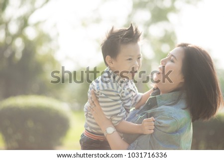 Mother playing with son  in the field. Happy family life style concept.