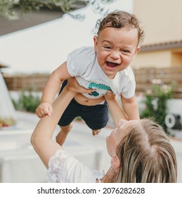 Mother Plays With The Baby, Tossing Him. 