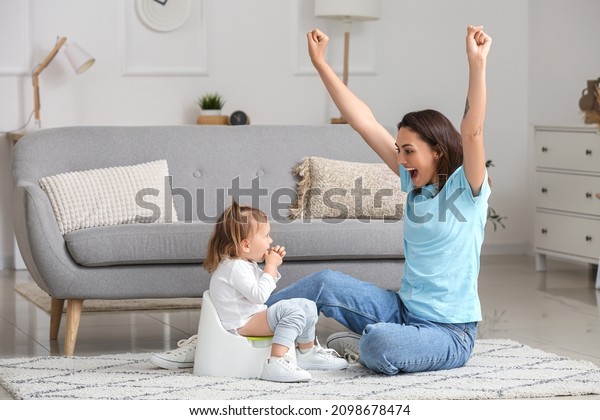 Mother potty\
training her little daughter at\
home