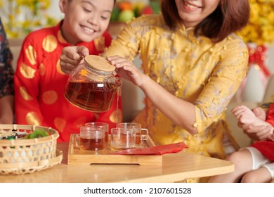 Mother pouring tea for her son at Chinese New Year celebration - Powered by Shutterstock