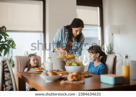 Mother prepares breakfast for children, in the morning. Maternal love and care for household and family.