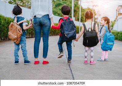 Mother And Pupil And Kids Holding Hands Going To School In First Class With Schoolbag Or Satchel Walking To School Bus, Parent And Son,sister Preschool 