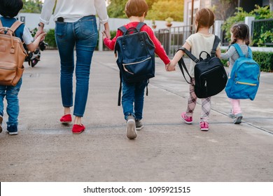Mother and pupil and kids holding hands going to school in first class with schoolbag or satchel walking to school bus, Parent and son,sister preschool 