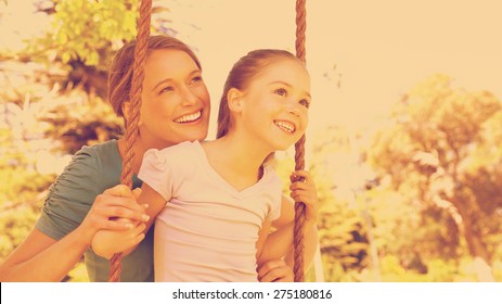 Mother Pushing Her Daughter On A Swing