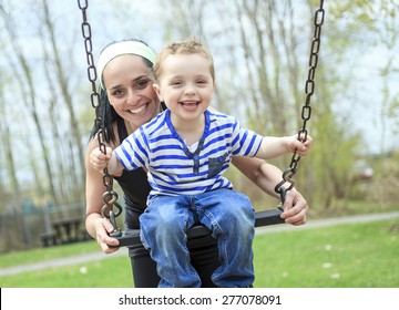 Mother Pushing Son On Swing 