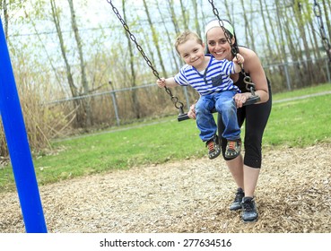 Mother Pushing Son On Swing