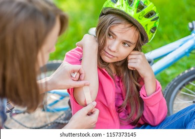 Mother Puts A Bandage On A Wound To Little Girl, Who Fell Off His Bicycle