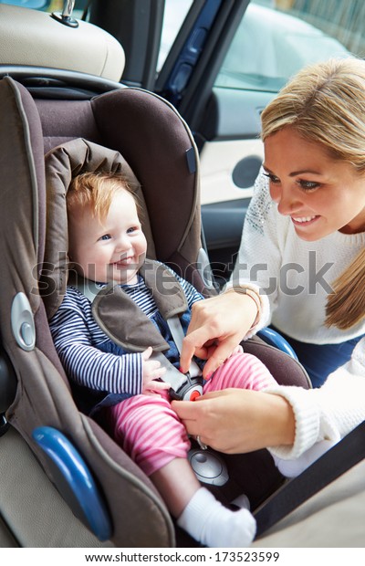 Mother Putting Baby Into Car\
Seat