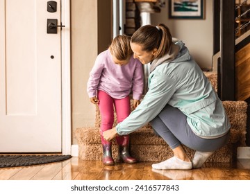 Mother putting child shoes on getting ready to leave home morning routine  - Powered by Shutterstock