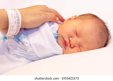 A Mother Putting Her Newborn Baby To Sleep At The Hospital. Childbirth And Infancy.