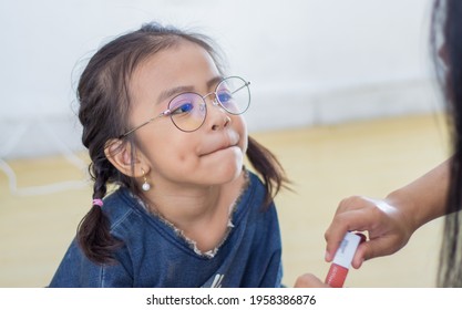 Mother Putting Lipstick On Her Daughter On Blurry Background. Mom Dresses Up And Makes Make-up Her Daughter. Selective Focus.