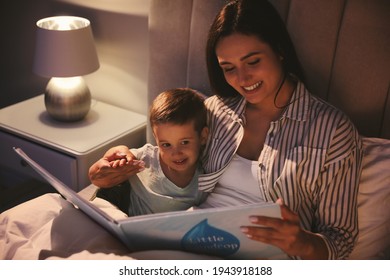 Mother Reading Bedtime Story To Her Son At Home