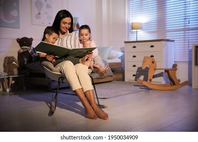 Mother Reading Bedtime Story To Her Children At Home