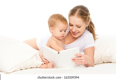 Mother Reading A Book The Baby In Bed Before Going To Sleep