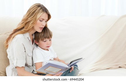 Mother Reading With Her Son On The Sofa