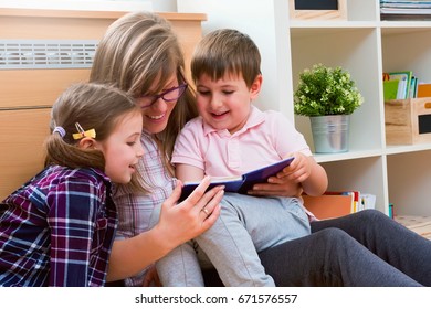 Mother reads a book to children at home