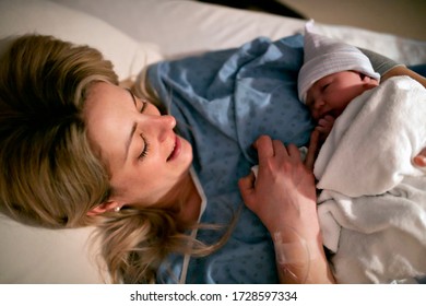 A Mother rest with her newborn baby relieve in bed immediately after a natural birth labor