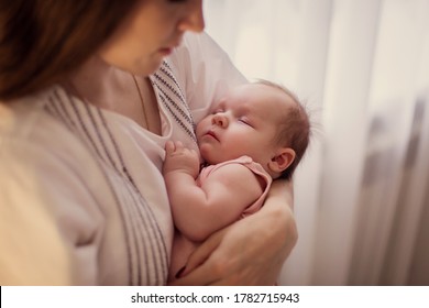 The Mother Rocks The Child. Portrait Of Sleeping Newborn In Mother's Arms. Caring Love Tenderness. Motherhood. Sings Lullaby. Baby Healthy Sleep. Young Mom. Infant Cute Sweet Little. Real Life