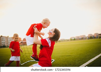 mother with russian flag on her cheek kissing her son on the football lawn by the gate - Powered by Shutterstock