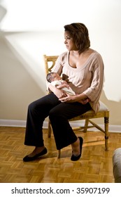 Mother With Sad Expression Holding Newborn