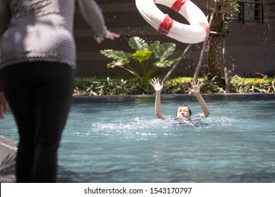 Mother Is Saving The Life Of A Daughter Using Ringbuoy To Rescue Drowning,asian Child Girl Struggling; Asking For Help In Water;female People Throwing Lifebuoy Help Woman Drowning In Swimming Pool