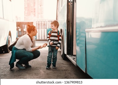 Mother Saying Talking With Her Son While Crouching In Front Of Bus. Kid Going To School.