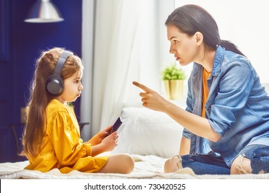 Mother Is Scolding Her Child Girl Playing On Phone. Family Relationships.