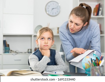 Mother scolding her daughter for poor grades in school