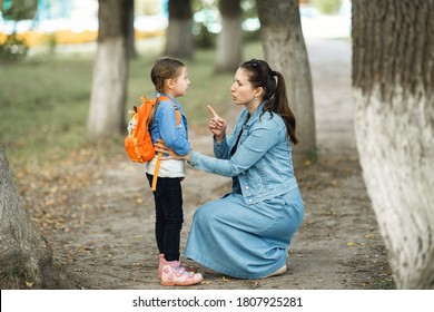 Mother Scolds Her Daughter In The Street. A Child Cries, A Woman Shakes Her Finger Because Of The Girl's Bad Behavior, While Walking In The Park. Education. Rule Of Conduct.