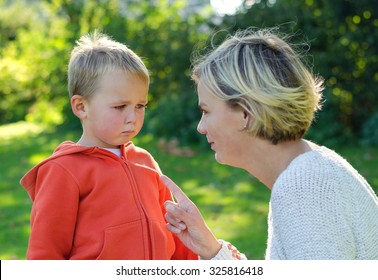 Mother scolds her son crying in the park - Shutterstock ID 325816418