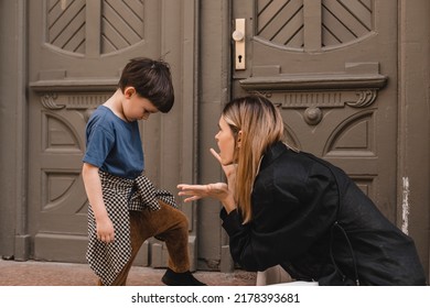 Mother Scolds Her Son On The Street. A Child Cries, A Woman Shakes Her Finger Because Of The Boy Bad Behavior, While Walking To Home. Rule Of Conduct. Woman Sitting, Boy Cover His Face And Cry.