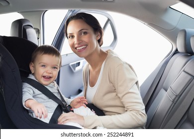 Mother Securing Her Baby In The Car Seat In Her Car