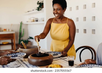 Mother serves a traditional Brazilian meal to her family. Homemade feijoada is served from clay pots on the dining table, reflecting the joy of home-cooked cuisine and cherished family moments. - Powered by Shutterstock