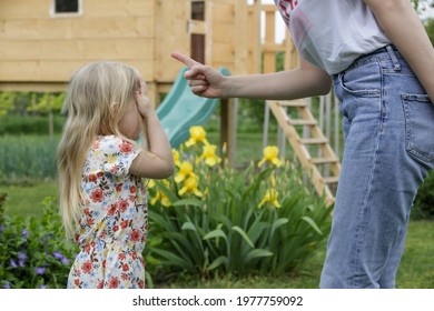 Mother Is Shouting At Her Daughter In Public Park. Upset Little Girl Is Crying In Front Of Her Mother.