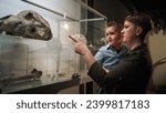 Mother showing animal bones to her toddler daughter during a natural history museum visit. Early education and experience concept.