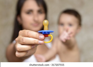 mother shows Pacifier For the baby