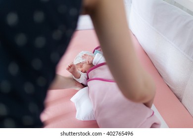 Mother Shushing Cute Baby Girl In Bed.