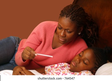 A Mother With A Sick Child Reading The Thermometer. With Clipping Path.