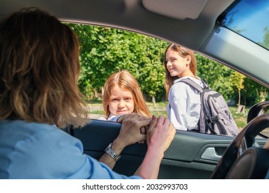 Mother Sitting Inside The Car And Leaving Her Daughters In School Uniform At School.