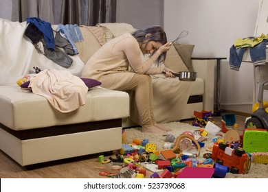 Mother Sitting On The Couch. Mom Tired To Tidy Up The House. Child Scattered Toys. Children's Room. Mess In The House