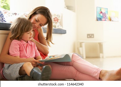 Mother Sitting With Son Reading Story Indoors