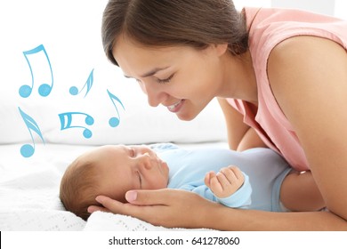 Mother With Sleeping Baby On Bed. Lullaby Songs And Music Concept