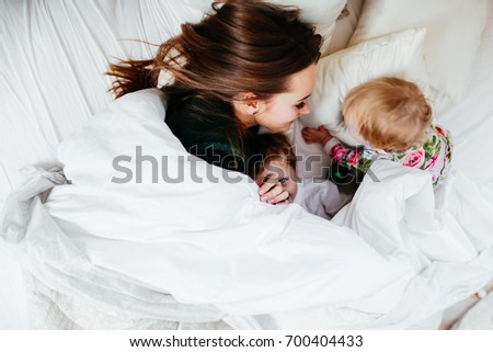 Similar – Relaxed mother and sons playing over the bed