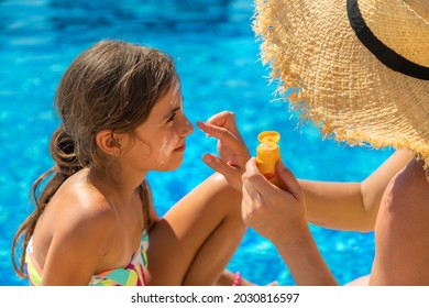 Mother smears sunscreen on the child face. Selective focus. Kid. - Powered by Shutterstock