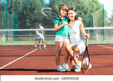 Mother smiling broadly. Mother smiling broadly before playing tennis with her lovely beaming daughter - Powered by Shutterstock