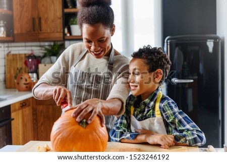 Mother and son carving pumpkin making Jack-o-Lantern