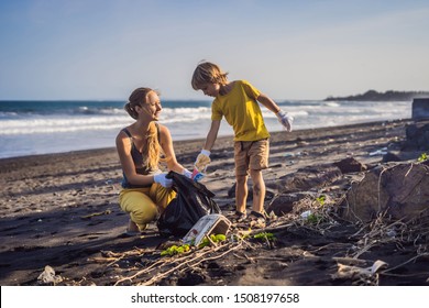 Mother and son are cleaning up the beach. Natural education of children - Powered by Shutterstock